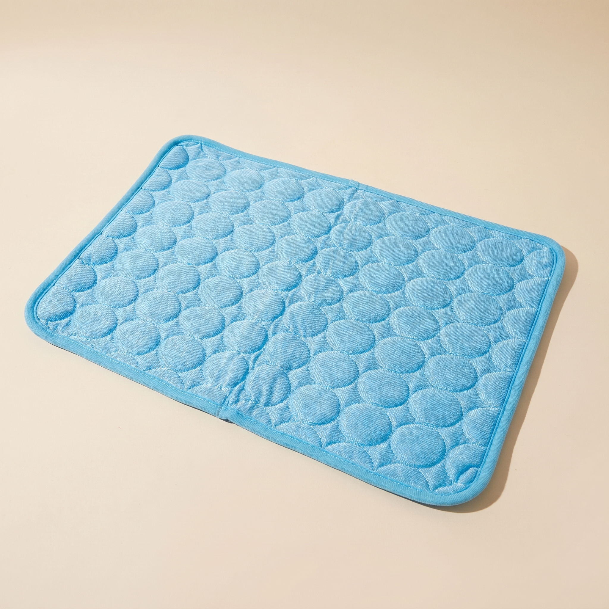 Chill Pad Pro ice-silk dog cooling mat on a clean sand studio background